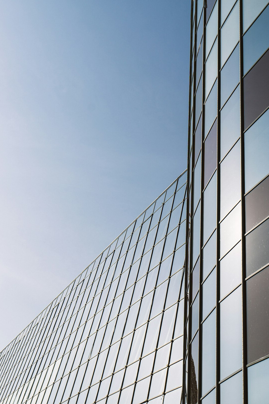 Modern glass office building facade under a clear sky