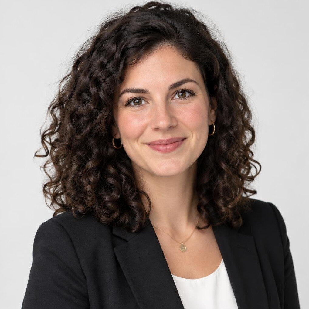 Studio portrait of a young European woman with curly dark hair in professional attire